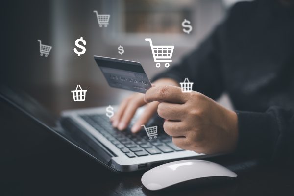 Hand holding credit card and using laptop. Businessman or entrepreneur working from home. Online shopping, e-commerce, internet banking, spending money, work from home concept. Internet online banking