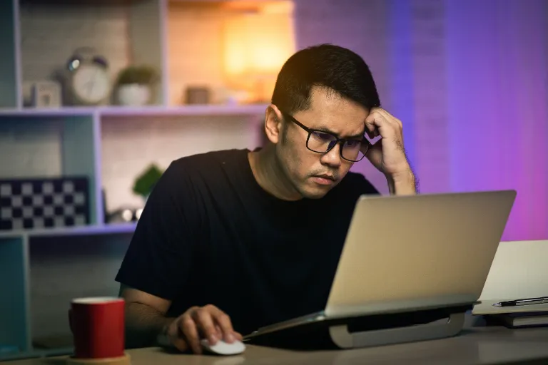 man-using-mobile-phone-while-sitting-table